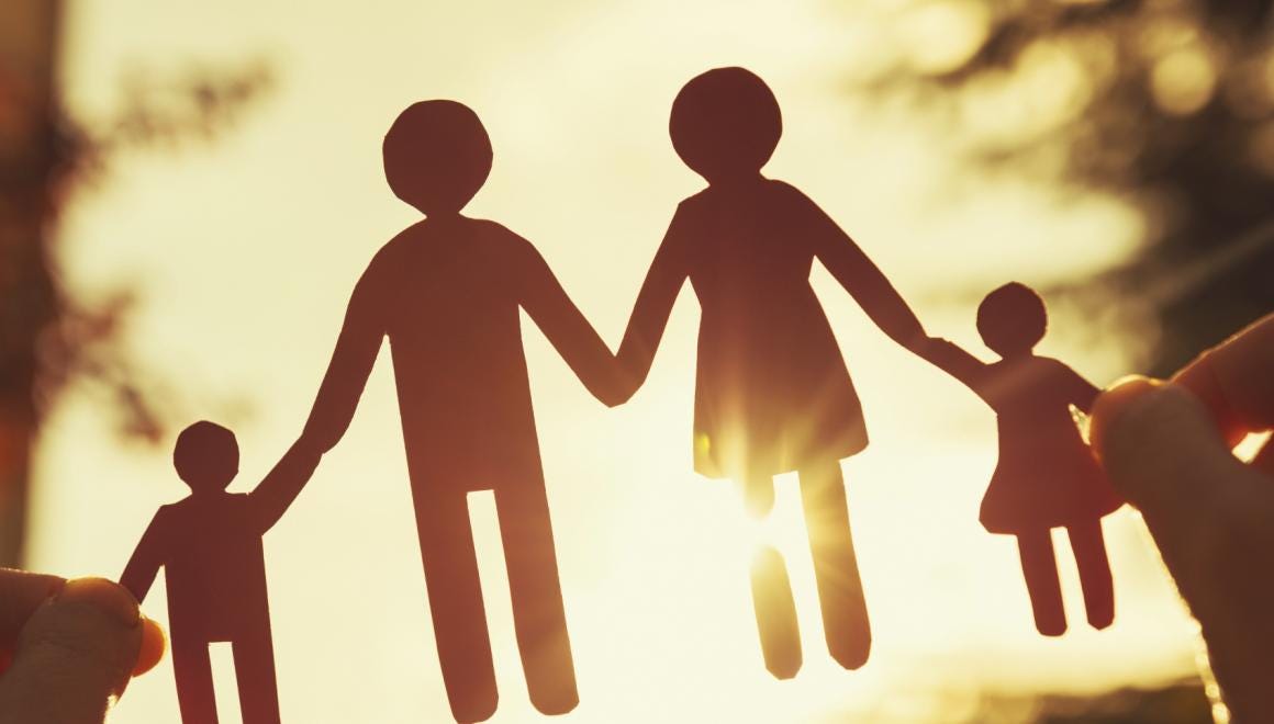 Family silhouette holding hands at sunset