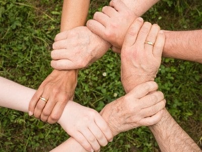 Hands joined together in a circle of support