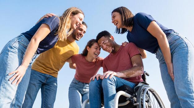 A diverse group of friends laughing together in a huddle